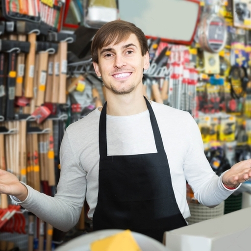 Friendly salesperson standing with a wide selection of hand tools including wrenches, pliers, screwdrivers, hammers, and more available at Starlinks